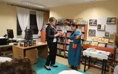 Prowadząca Zofia Piwowar wręcza prezent autorce