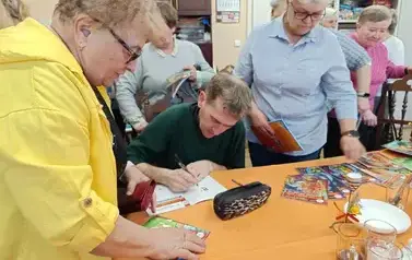 Zabdyr podpisuje książki seniorkom