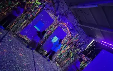 Grupa dzieci podczas warsztat&oacute;w malarskich ze światłem fluo