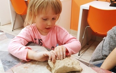 Najmłodsza uczestniczka tworzy swoją ceramiczną miseczkę