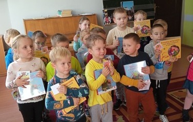 Przedszkolaki pozują do zdjęcia z książeczkami